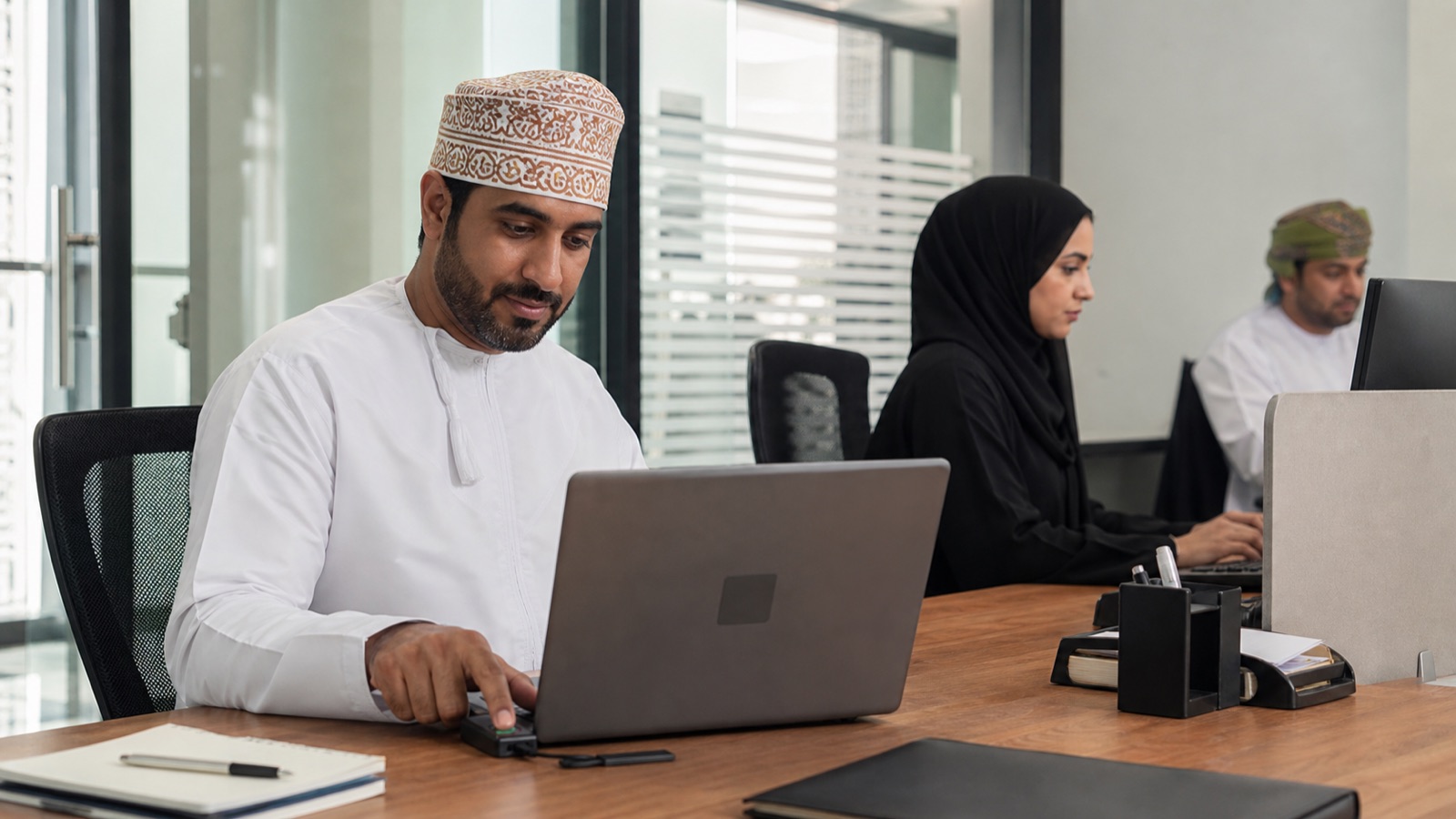 Oman employees completing secure sign-in on ordinary work devices